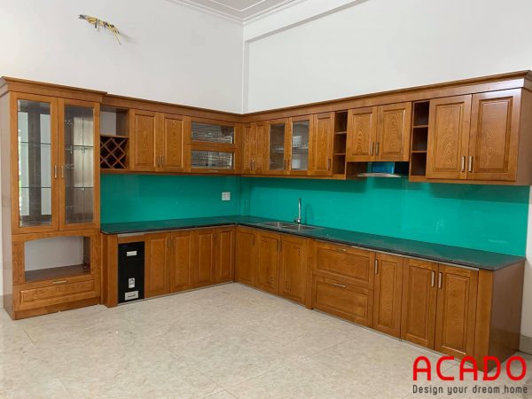 Tủ bếp gỗ sồi Nga dáng chữ L với kính bếp màu xanh ngọc hiện đại