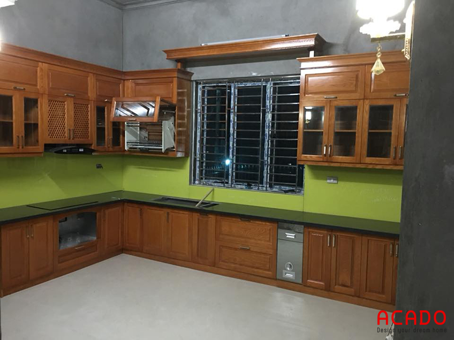 Gia chủ sử dụng chất liệu tủ bếp bằng gỗ sồi Nga màu vàng đậm mang lại không gian ấm cúng cho căn bếp. Có cửa sổ giúp không gian thêm khô thoáng sáng sủa hơn