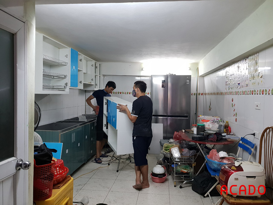 Tủ bếp inox cánh Acrylic đang được thợ thi công Acado lắp đặt cho khách hàng tại Phú La