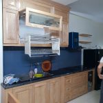 Tủ bếp gỗ tự nhiên kiểu dáng thông minh, sử dụng phụ kiện bếp giá bát nâng hạ giúp người nội trợ dễ dàng hơn trong việc cất bát đũa