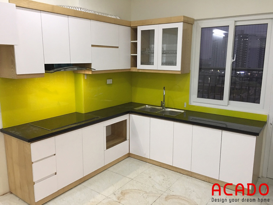 Tủ bếp trắng, kết hợp kính bếp màu vàng sang trọng, hợp phong thủy.