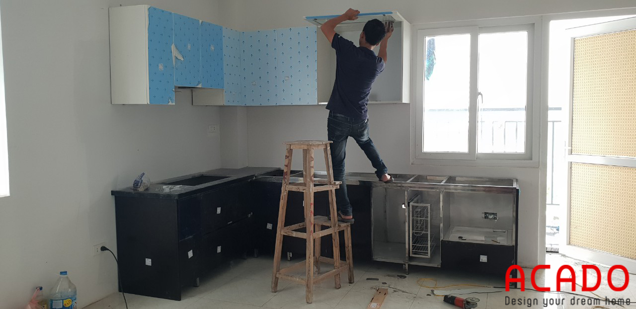 Thợ thi công đang thi công đặt tủ bếp - nội thất Acado