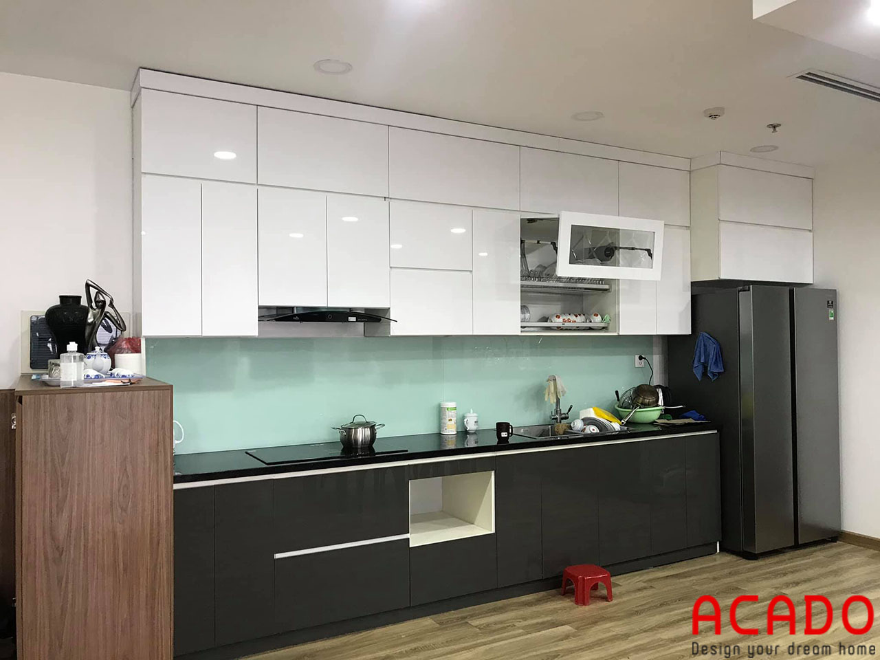 Tủ bếp thùng nhựa Picomat cánh Acrylic bóng gương kết hợp kính bếp màu trắng xanh tạo nên một căn bếp hoàn hảo