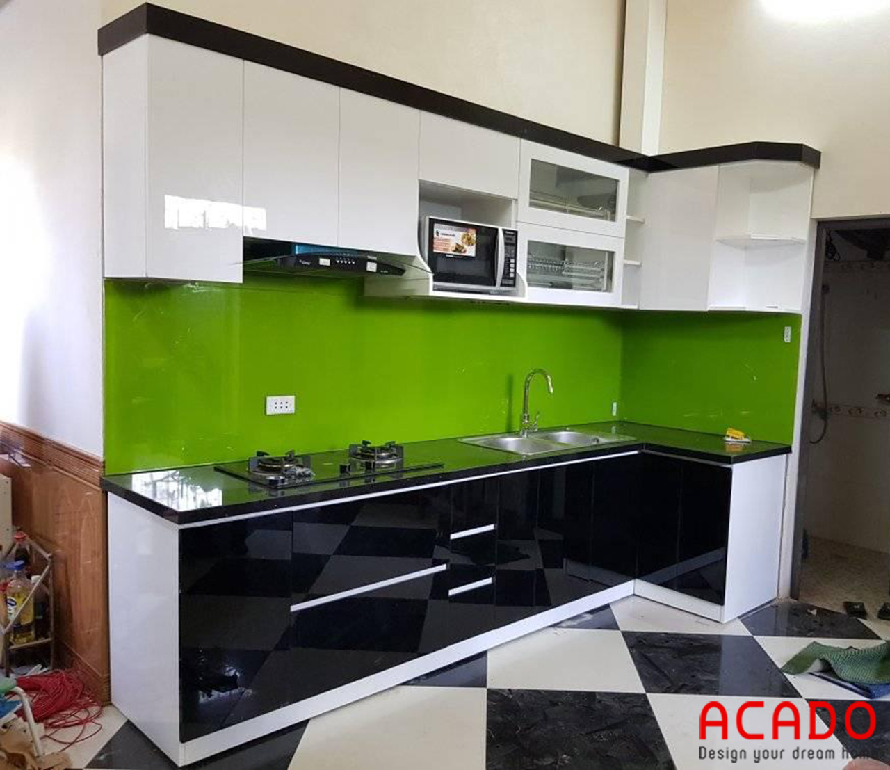 Tủ bếp gỗ công nghiệp sử dụng kính bếp màu xanh lá tạo điểm nhấn cho căn bếp