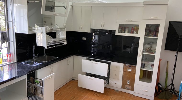 Tủ bếp Melamine màu trắng hiện đại và kính bếp màu đen làm điểm nhấn
