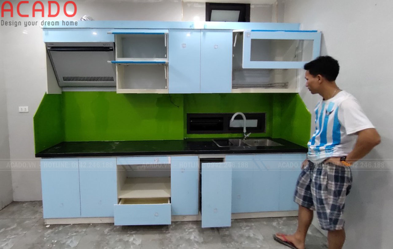Tủ bếp màu trắng kết hợp với kính màu xanh tạo cảm giác trẻ trung, hiện đại