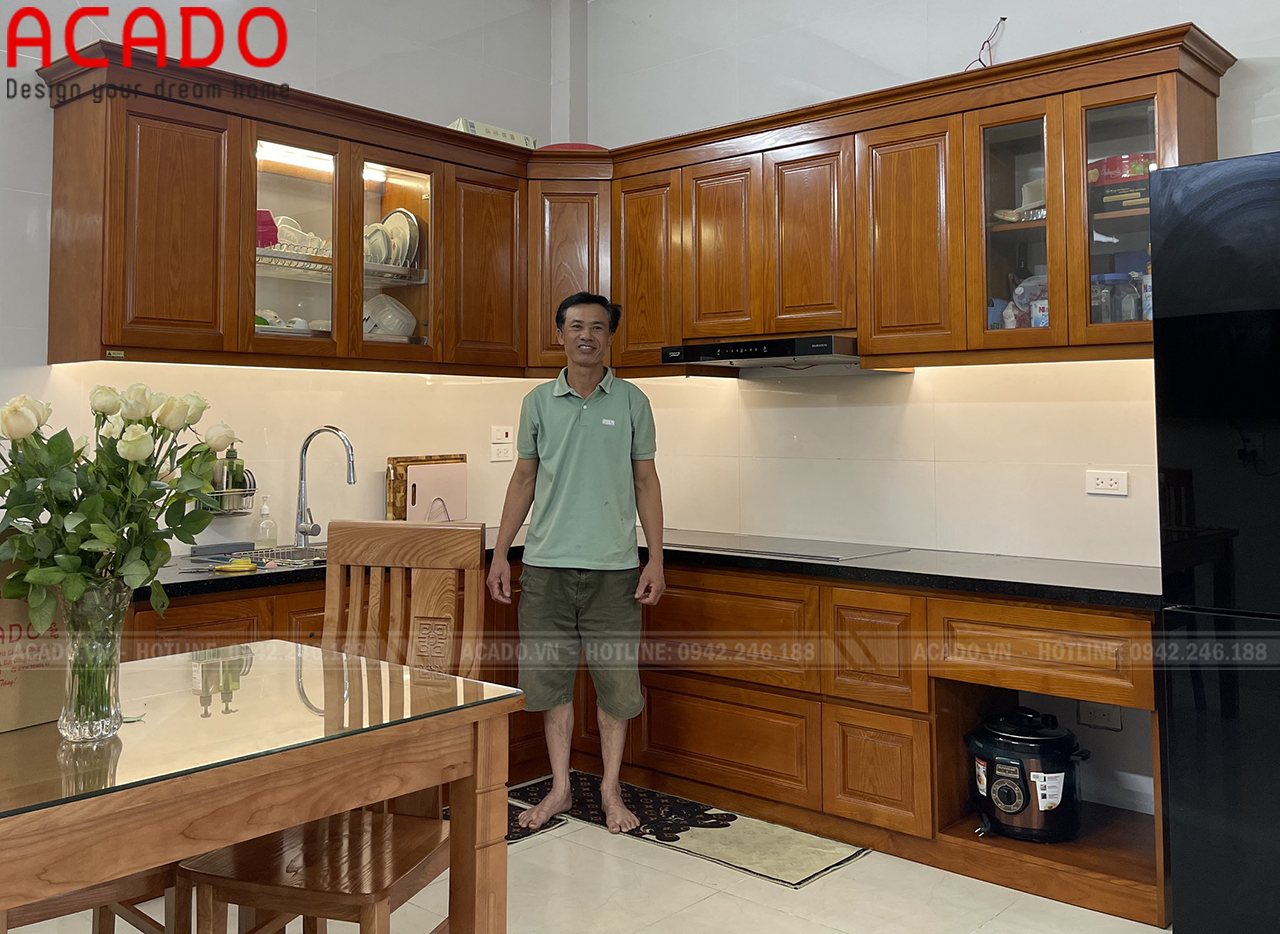 Tủ bếp gỗ xoan đào màu cánh dán đậm được thiết kế theo hình chữ L mang lại không gian bếp sang trọng và tiện nghi